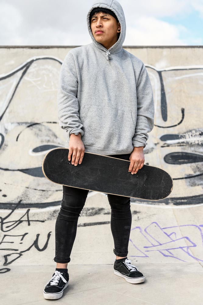 Young Skater Posing With Skateboard At Skate Park