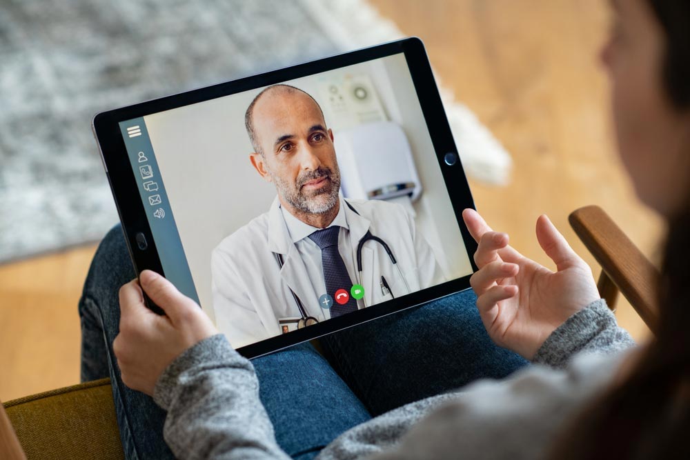 a female client during her virtual treatment, having video call with a doctor