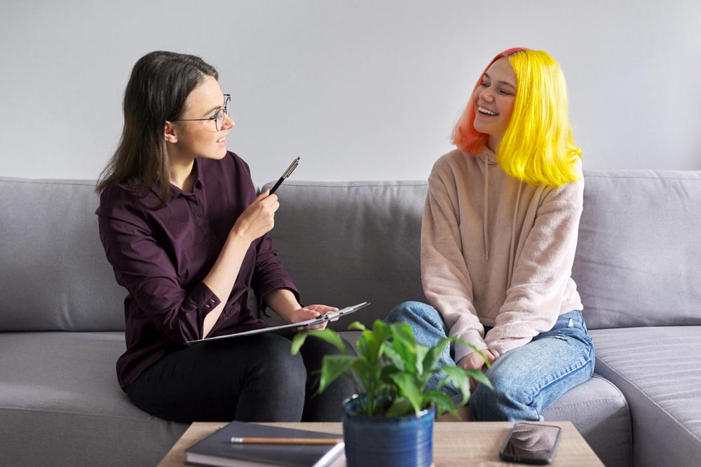 a teen girl being interviewed by a psychologist at school