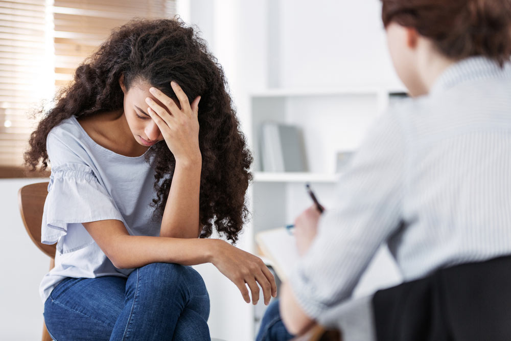 a young woman suffering from PTSD consults a professional psychotherapist