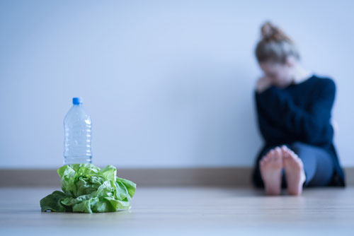 photo of a girl with anorexia sitting on the floor