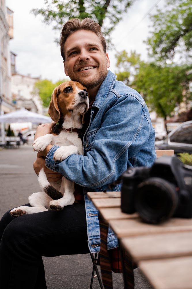 photo of a happy young man smiling hugging his lovely dog