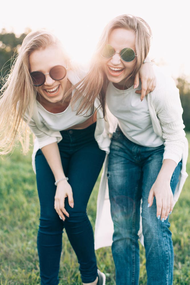 two young women having fun on the green field