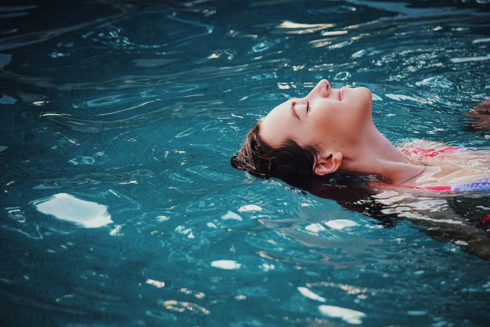 a beautiful woman floating in the swimming pool