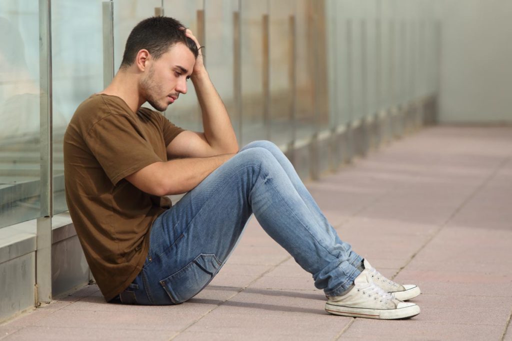 young man with depression sitting on the floor
