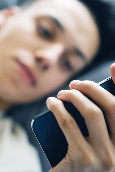 a man lying in bed addicted to social media