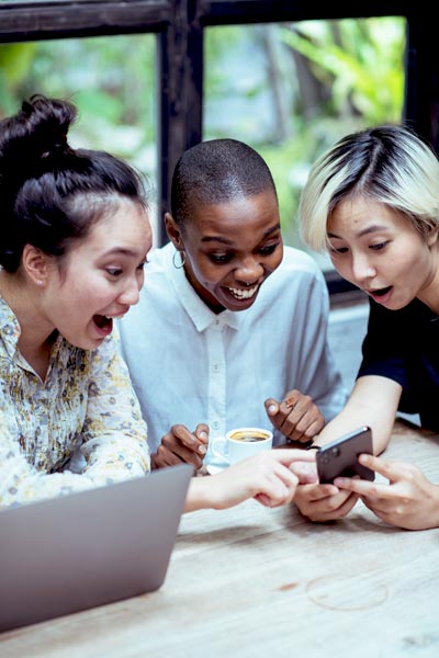 three female friends facinated about a content on social media