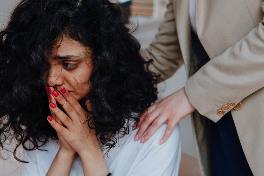 a woman with mental health issue being comforted by a woman