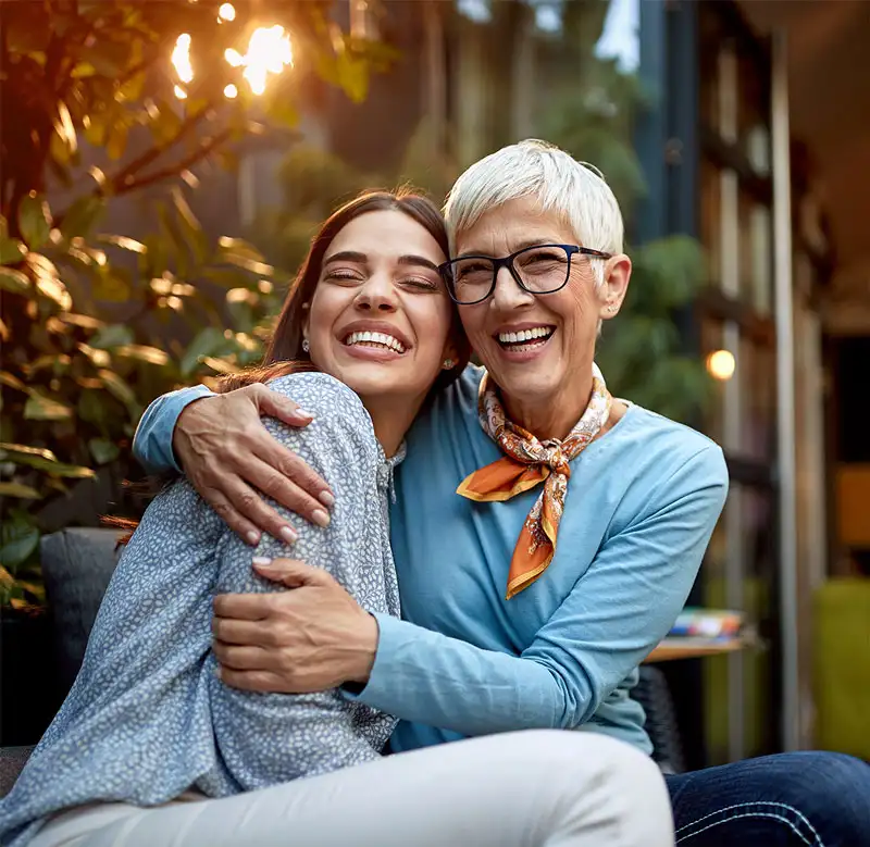 a senior mother and adult daughter, hugging, smiling. Love, affection, happiness concept