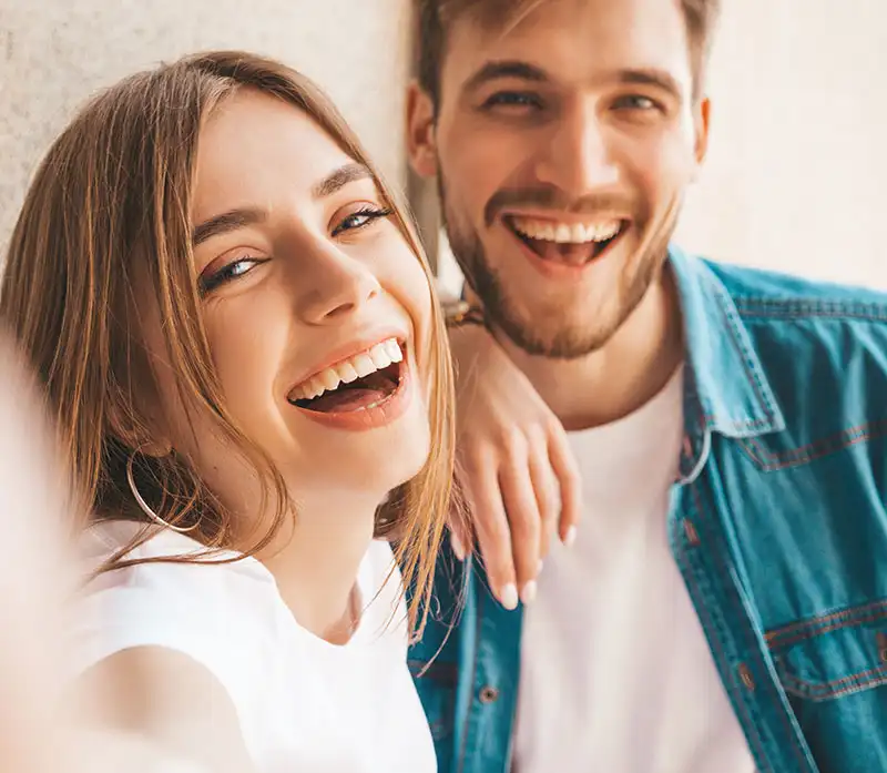 a happy woman and man smiling for camera near drug and alcohol treatment center in Orange County California