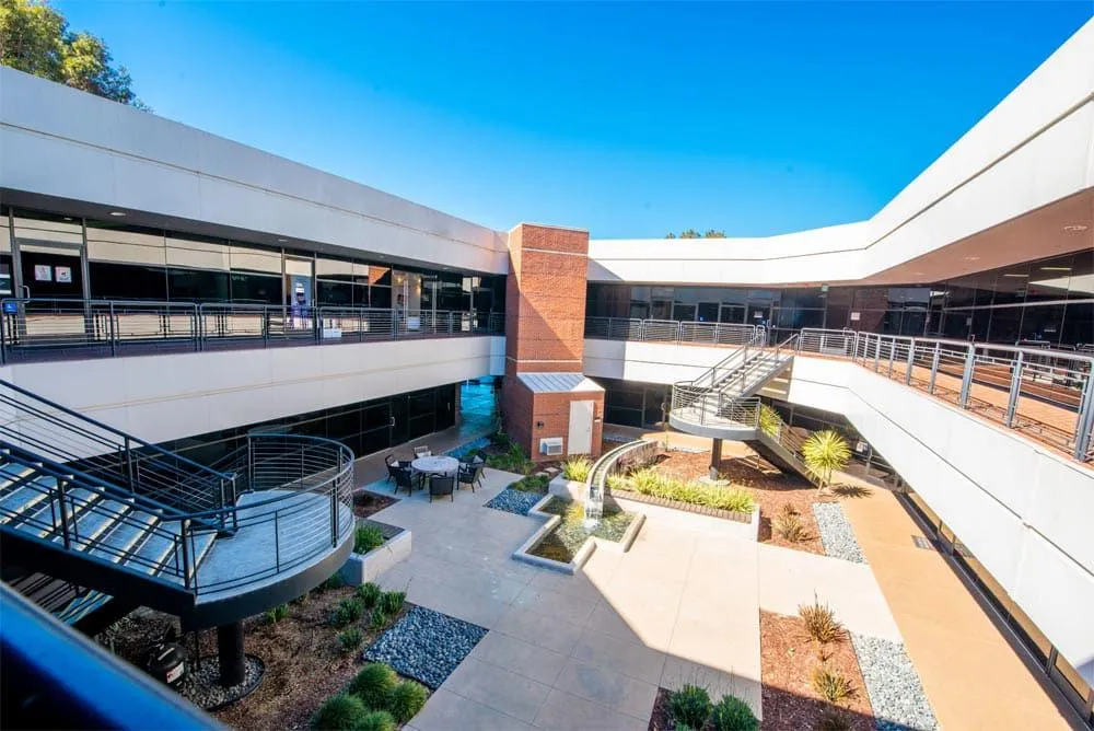 Modern outdoor courtyard at Compassion Recovery Centers in Orange County, featuring a serene fountain, seating area, and professional clinical offices for outpatient mental health care.