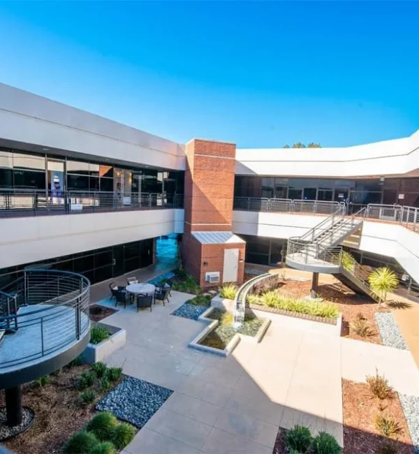 Modern outdoor courtyard at Compassion Recovery Centers in Orange County, featuring a serene fountain, seating area, and professional clinical offices for outpatient mental health care.