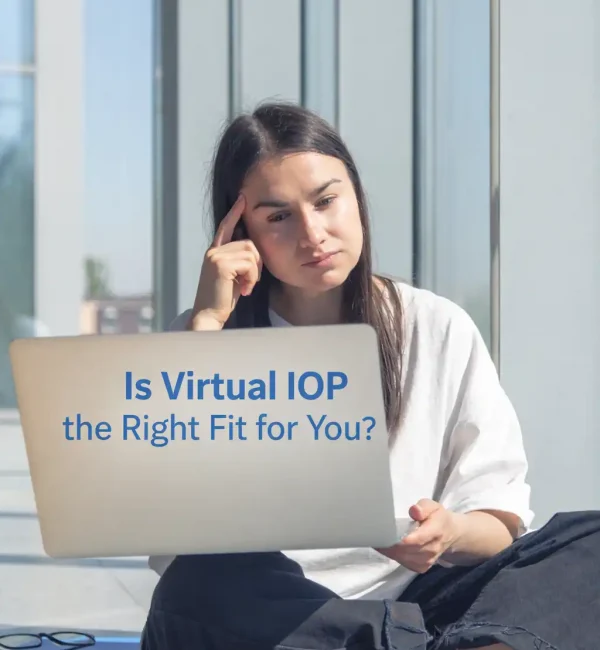 A woman sitting outside with a laptop contemplating if a virtual intensive outpatient program (IOP) is right for her recovery journey.